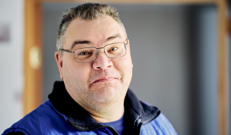 Man met bril kijkt in de camera.