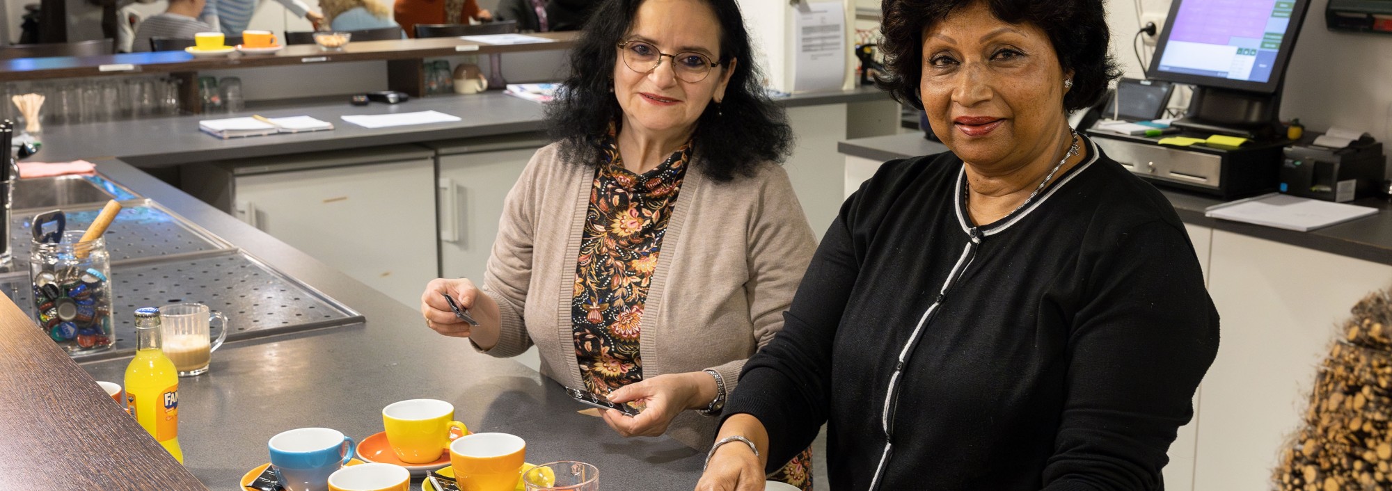 Twee vrouwen schenken koffie in.