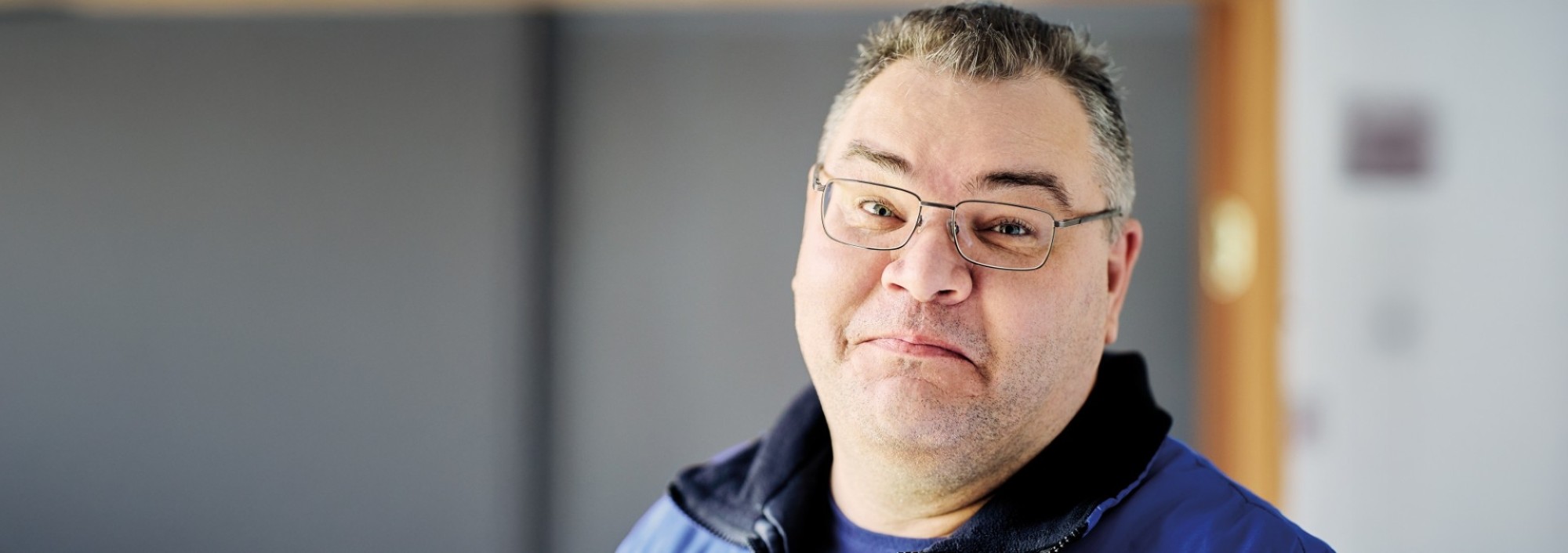 Man met bril kijkt in de camera.