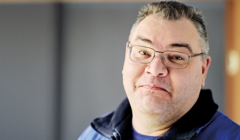 Man met bril kijkt in de camera.