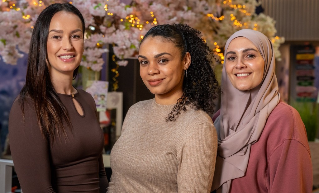 Drie vrouwen poseren voor de foto.