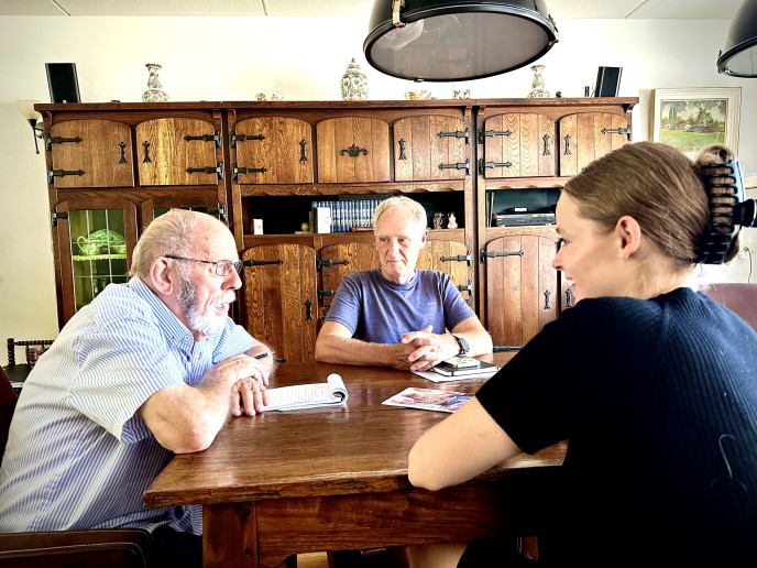 Twee manenn en een vrouw met elkaar in gesprek