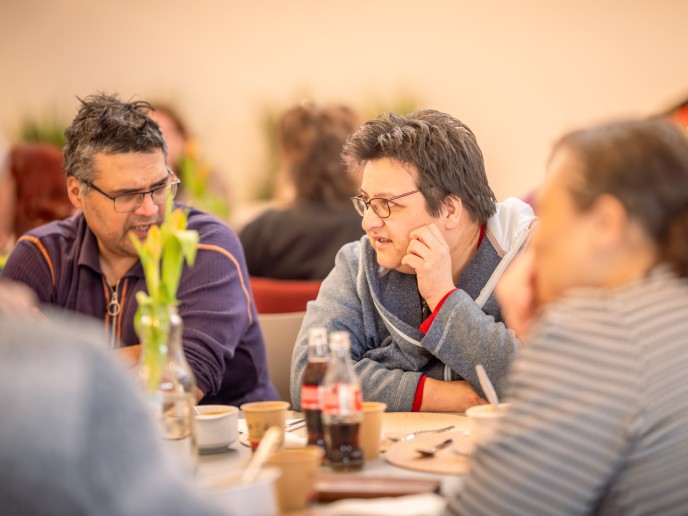 Drie mensen met elkaar in gesprek.