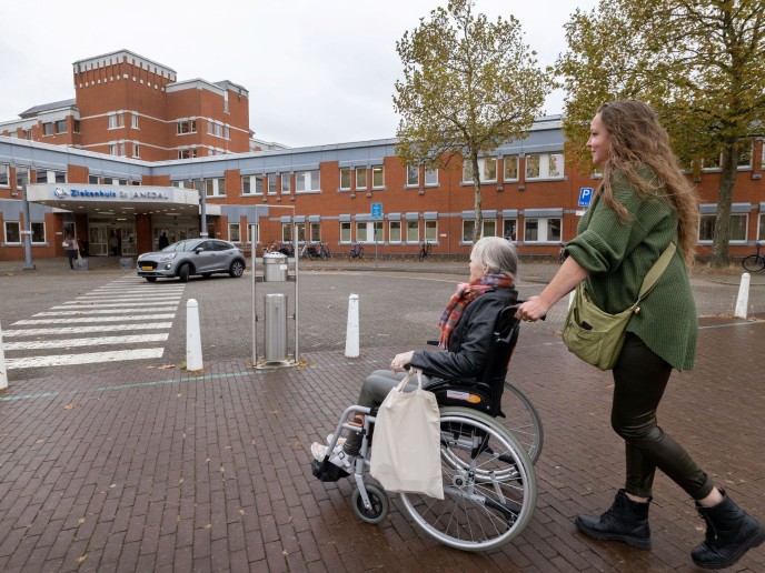 Vrouw duwt vrouw in rolstoel