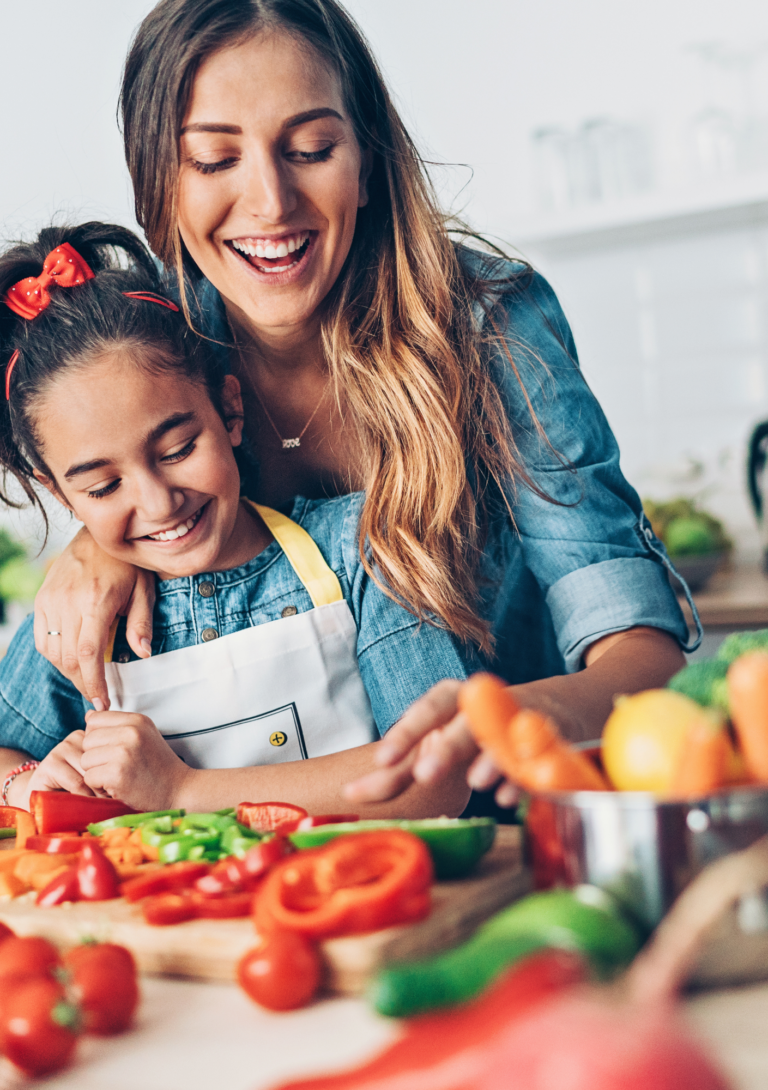 Jonge vrouw, kind met schort, samen koken